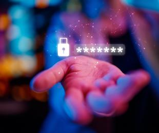 Mano de una persona con caracteres de contraseña y símbolo de candado encima proyectado de manera holográfica.